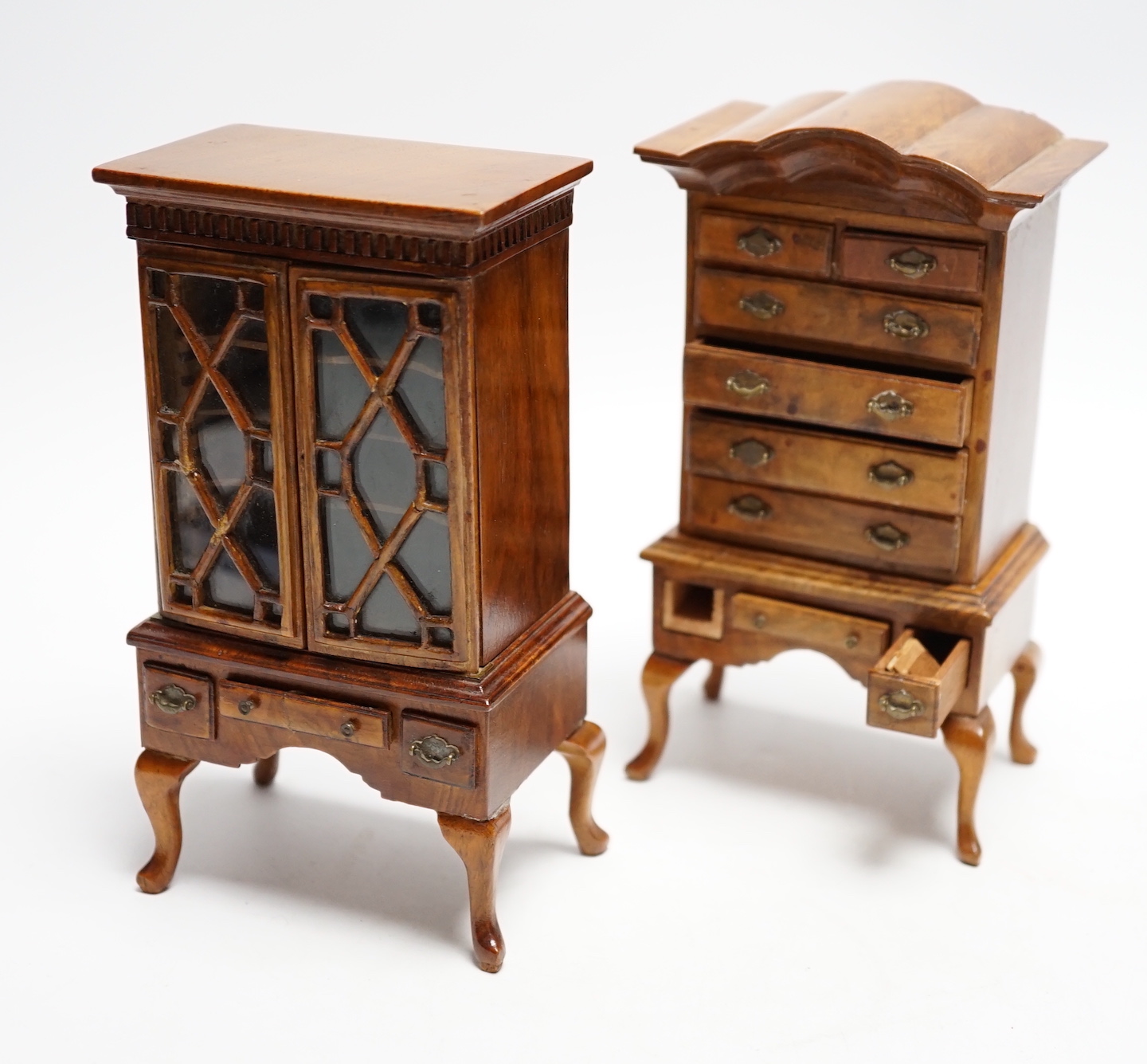 Two pieces of early 20th century miniature furniture - a mid-18th century style walnut bookcase, indistinctly signed on the base (15.5cm high) and a mid-18th century-style walnut chest on stand (16cm high). (Provenance B